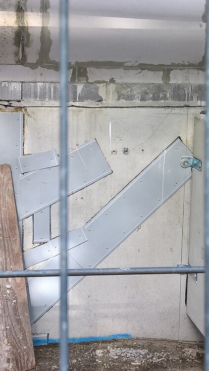 Baustelle mit Metallstufen und Stahlkonstruktion an Betonwand