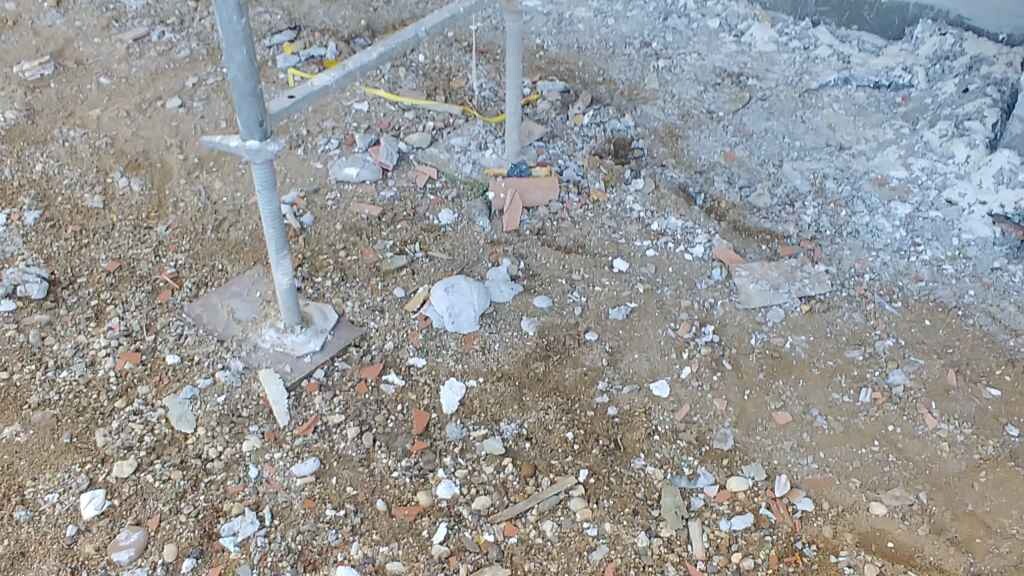 Baustelle mit Schutt, Metallstützen und Erdarbeiten im Rohbau