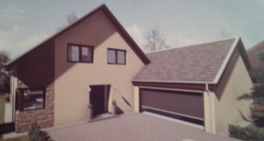 Vorderansicht eines modernen Einfamilienhauses mit Garage und heller Fassade.