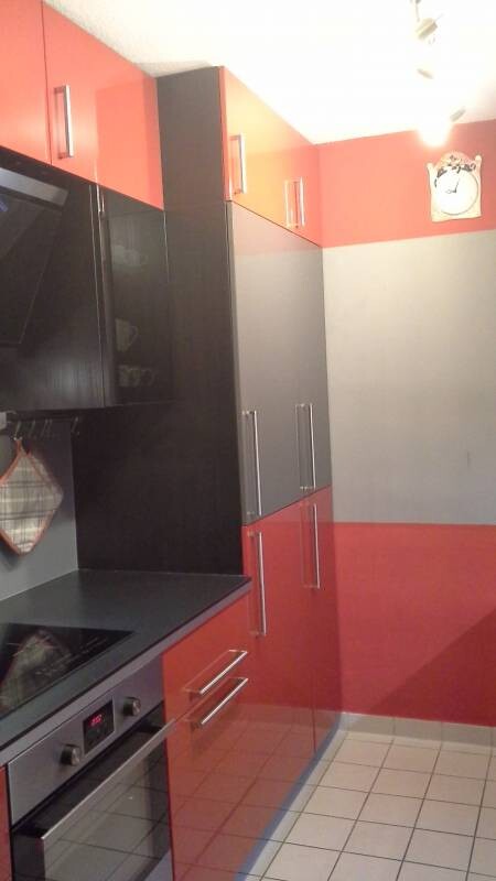 Moderne Küche mit roten und schwarzen Fronten und Edelstahlgriffen.