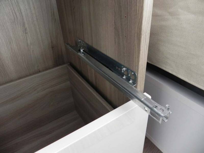 Metall-Schubladenführung in einem Holzschrank, seitlich montiert und sichtbar.