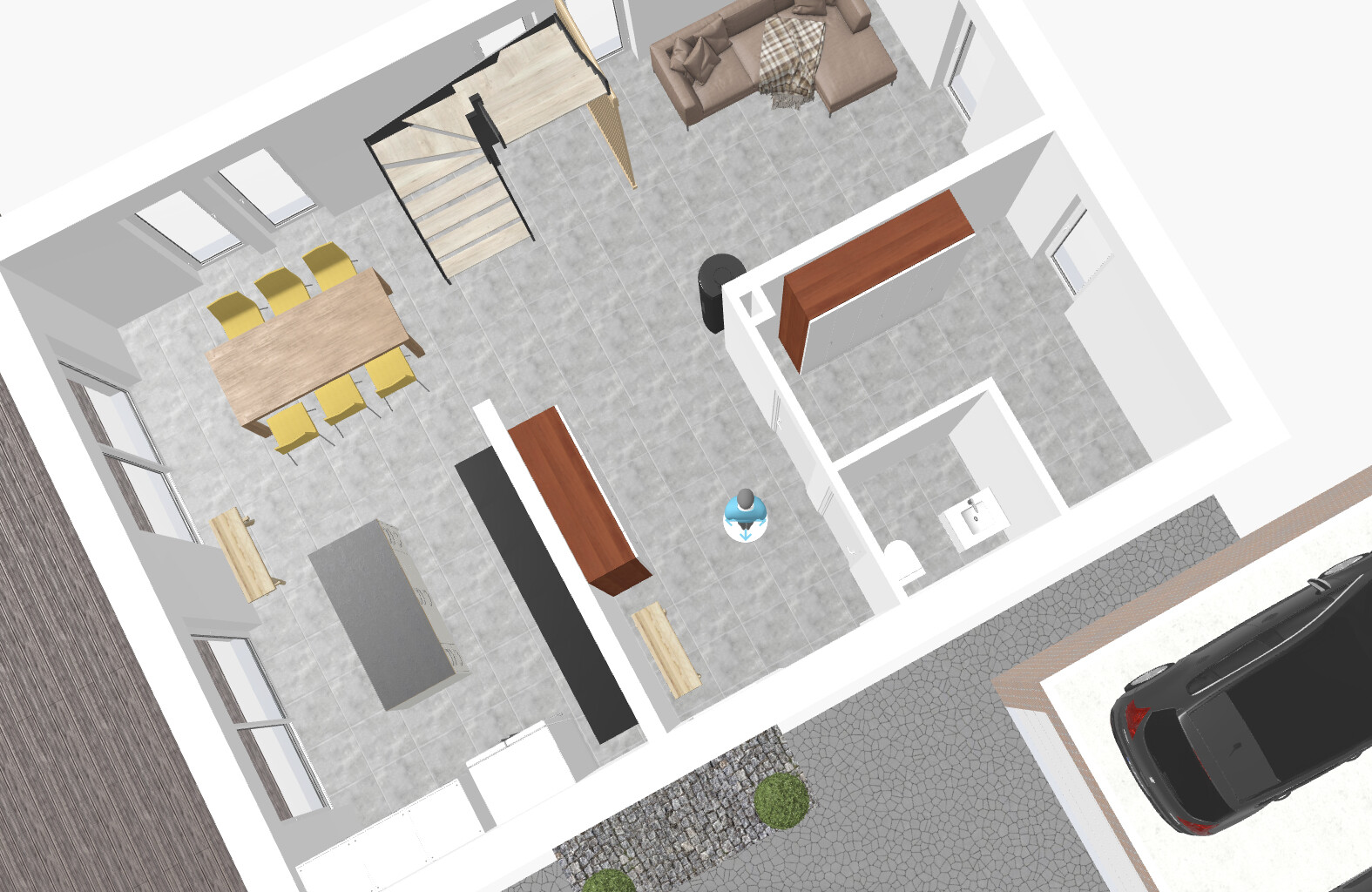 Draufsicht auf Wohn- und Essbereich mit Esstisch, Gelb-Stühlen, Kücheninsel, Treppe und Sofa.
