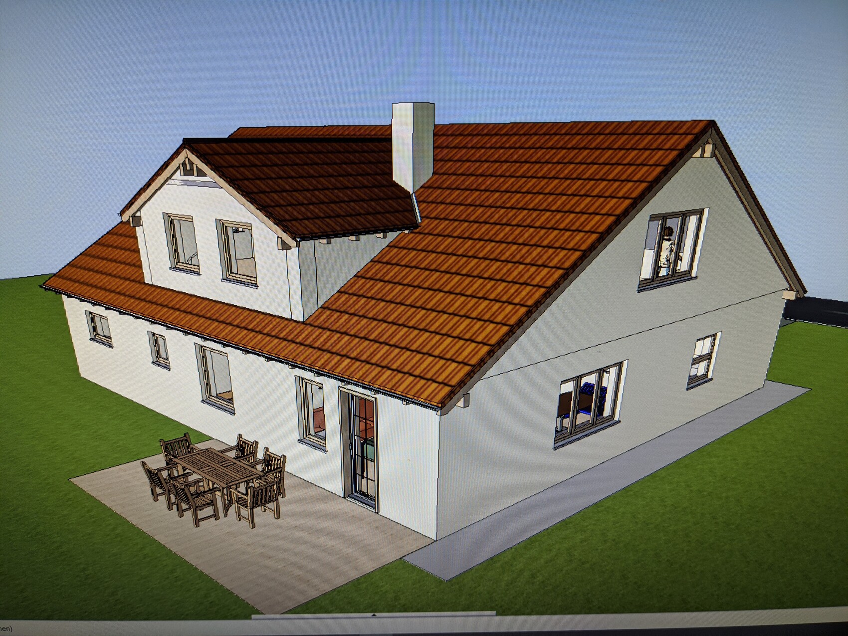 3D-Modell eines zweigeschossigen Hauses mit rotem Ziegeldach und Terrasse mit Esstisch.