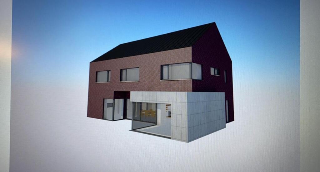 Modernes rotes Backstein-Haus mit grauer Anbau-Kubus und großen Fenstern.