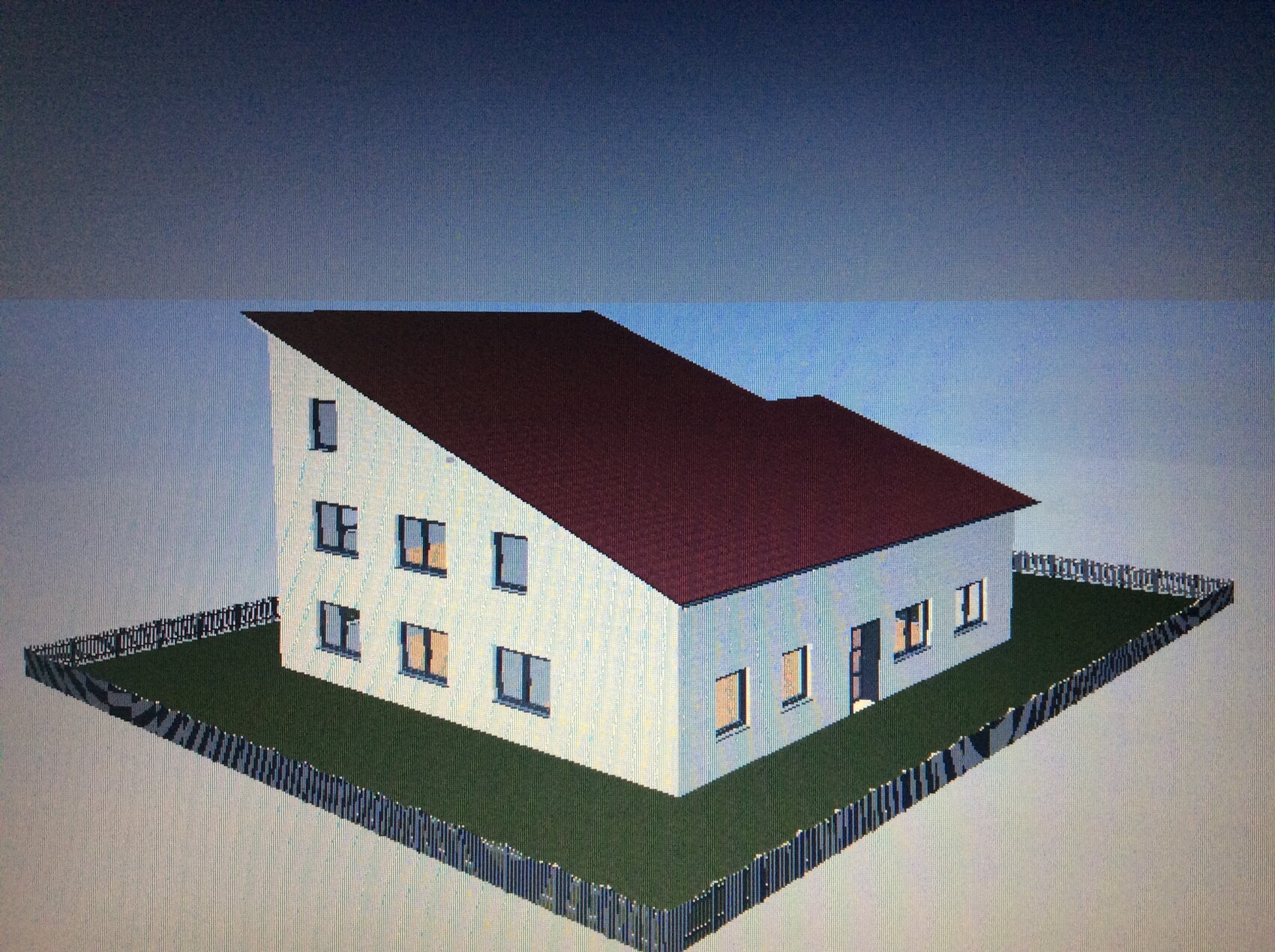 Weißes zweistöckiges Haus mit rotem Satteldach, vielen Fenstern, von Zaun umgeben.