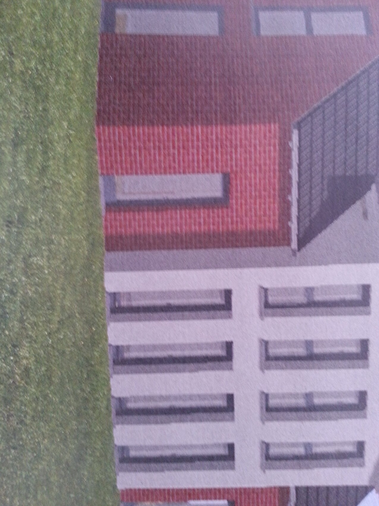 Vogelperspektive eines modernen Hauses mit rotem Dach und weißer Fassade neben Grünfläche.