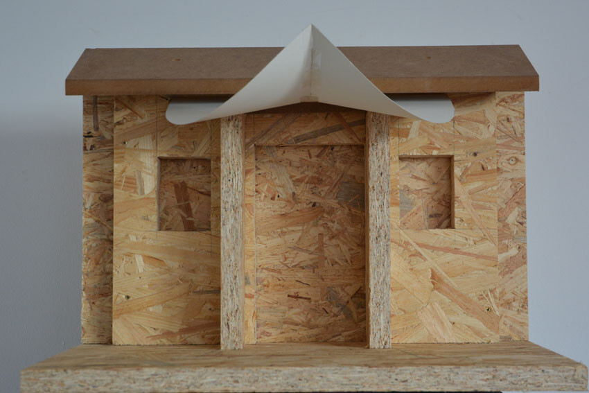 Kleines 3D-Hausmodell aus OSB-Holzplatten mit einfachem Dach.