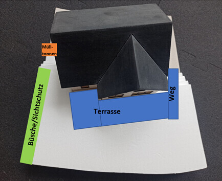 Kleines 3D-Hausmodell mit Terrasse, Weg und Mülltonnenbereich neben dem Haus.