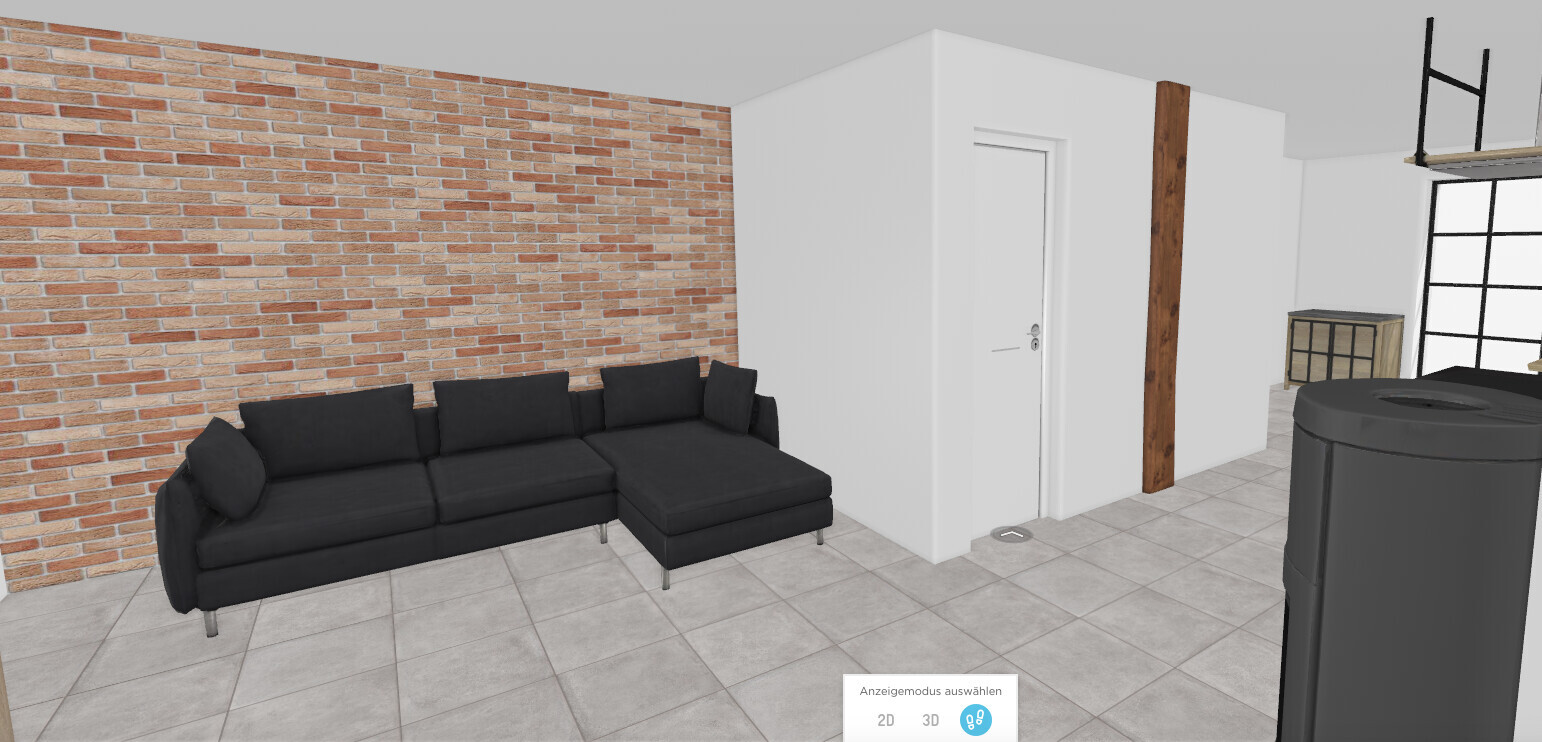 Wohnzimmer mit Backsteinwand, schwarzem Ecksofa, weißem Türrahmen und Holzbalken.