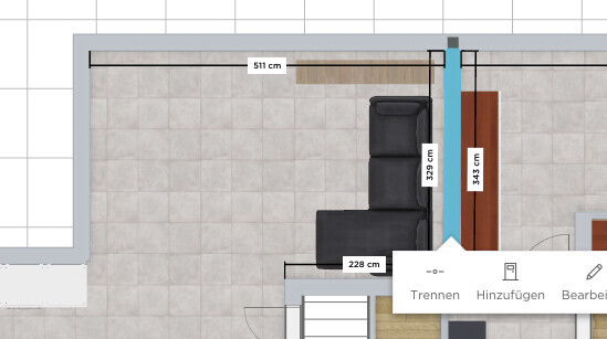 Grundriss eines Wohnzimmers: grauer Fliesenboden, schwarze L-Couch, blaue Säule.