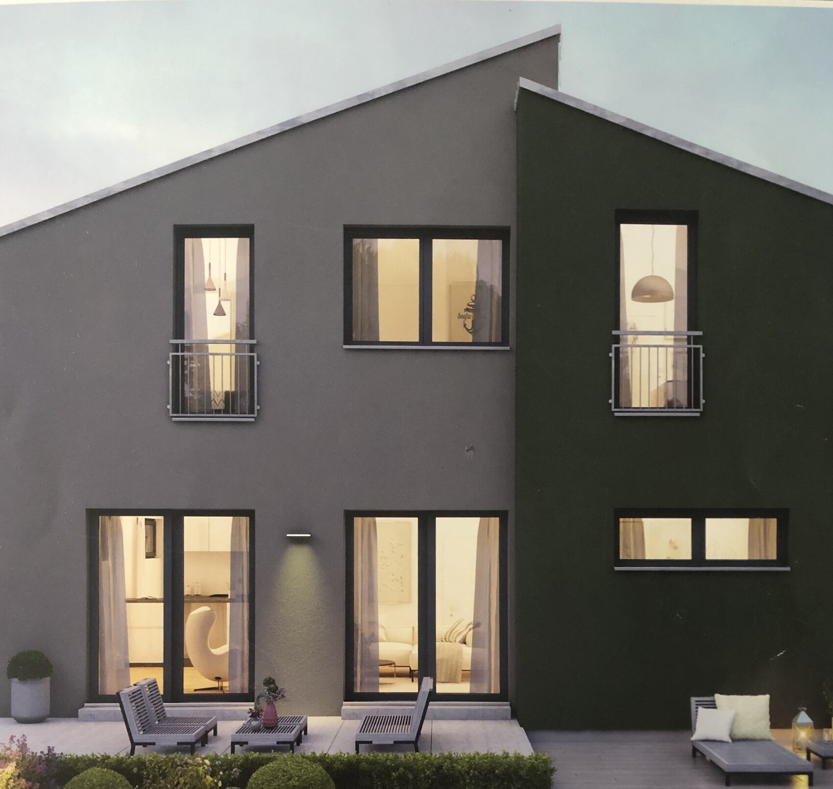 Moderne zweifarbige Hausfassade mit Terrasse und Balkonen