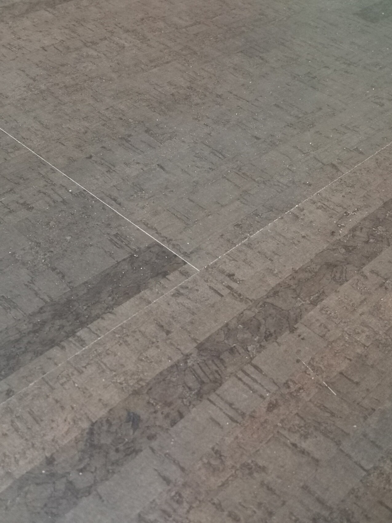 Grauer Steinboden mit quadratischen Platten, klare Fugenlinien, staubig.