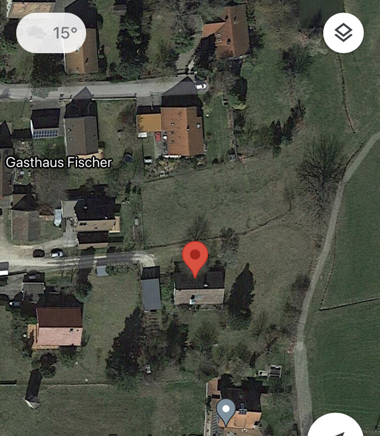 Satellitenbild eines Dorfes; Gasthaus Fischer, rote Markerposition am Haus, Felder.