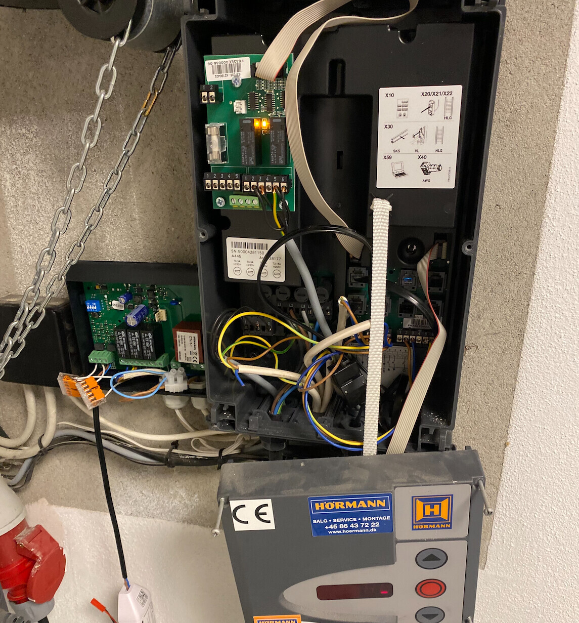 Offenes Schaltschrank-Gehäuse mit Steuerplatine, Kabelbäumen und Hörmann-Antrieb.