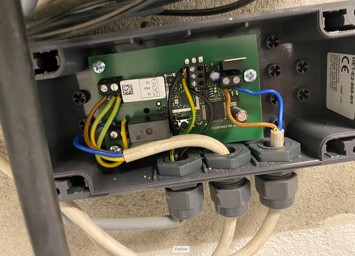 Elektronische Steuerplatine mit gelben, blauen und grünen Kabeln in einem Gehäuse.