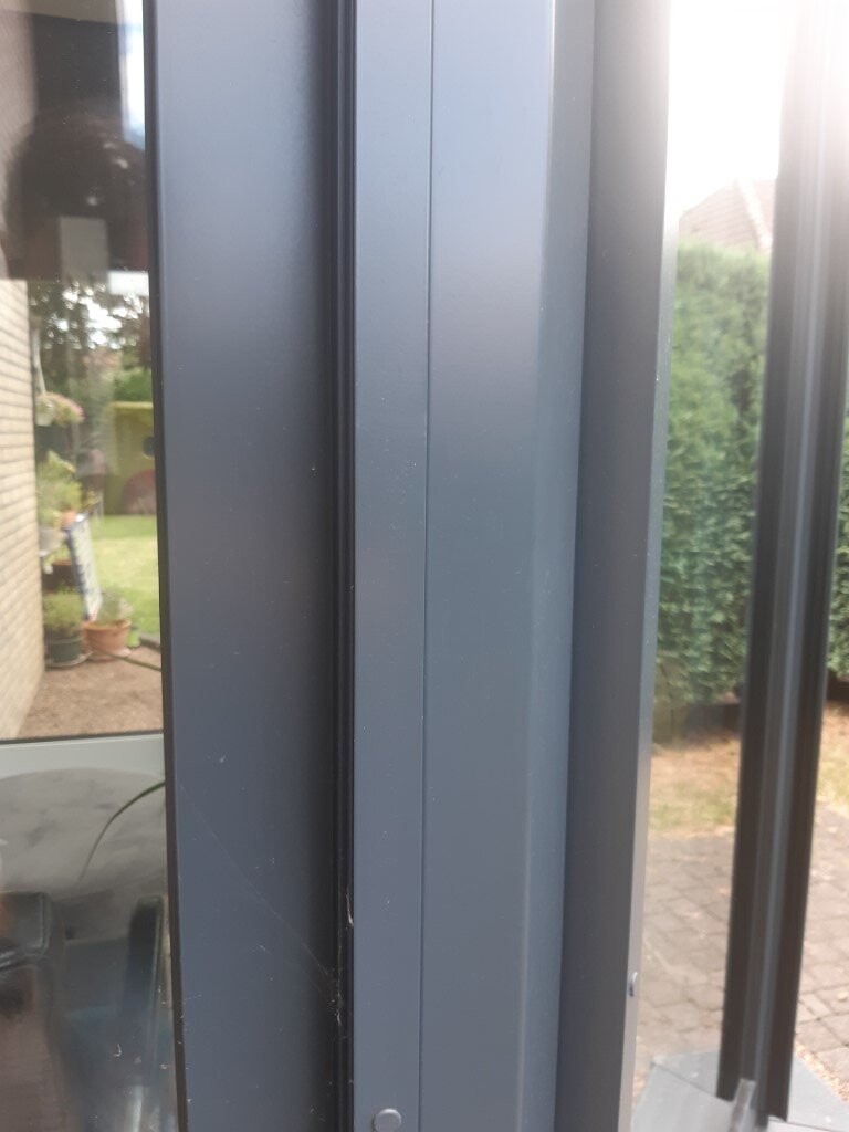 Nahaufnahme eines blauen Metall-Fensterrahmens mit Glasfenster, Außenansicht