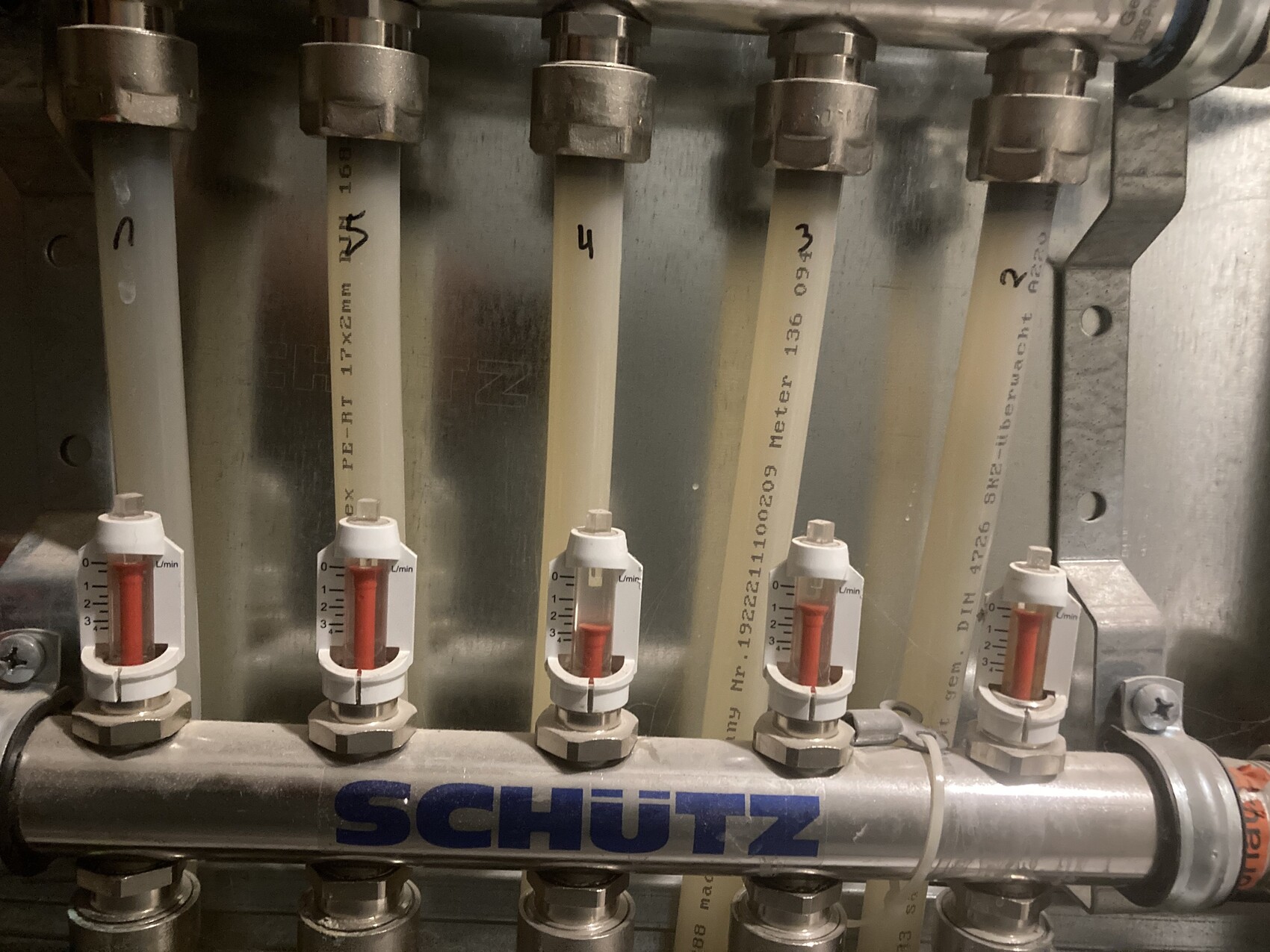 Mehrere Rotameter mit rotem Schwimmer an Metallrohrleitung, SCHUETZ-Aufschrift.
