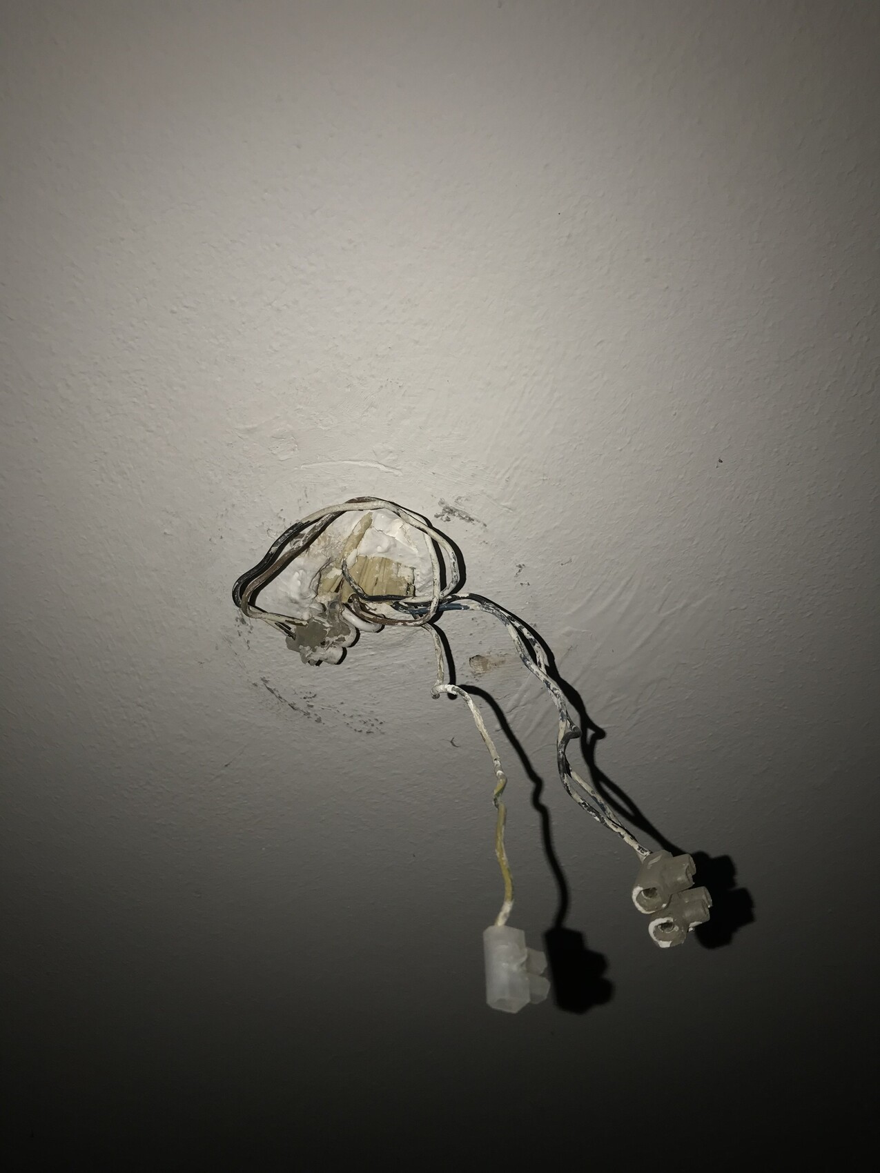 Offenes Loch in der Decke mit lose hängenden Elektrodrähte und Steckern.