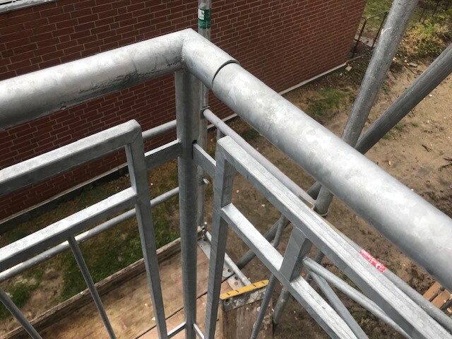 Stahlgerüst mit Geländer und Querverstrebungen auf einer Baustelle, Blick von oben