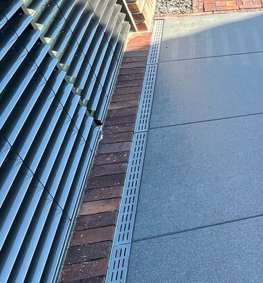 Außenbereich einer Terrasse mit Drainageschlitz und Fassadenlamellen