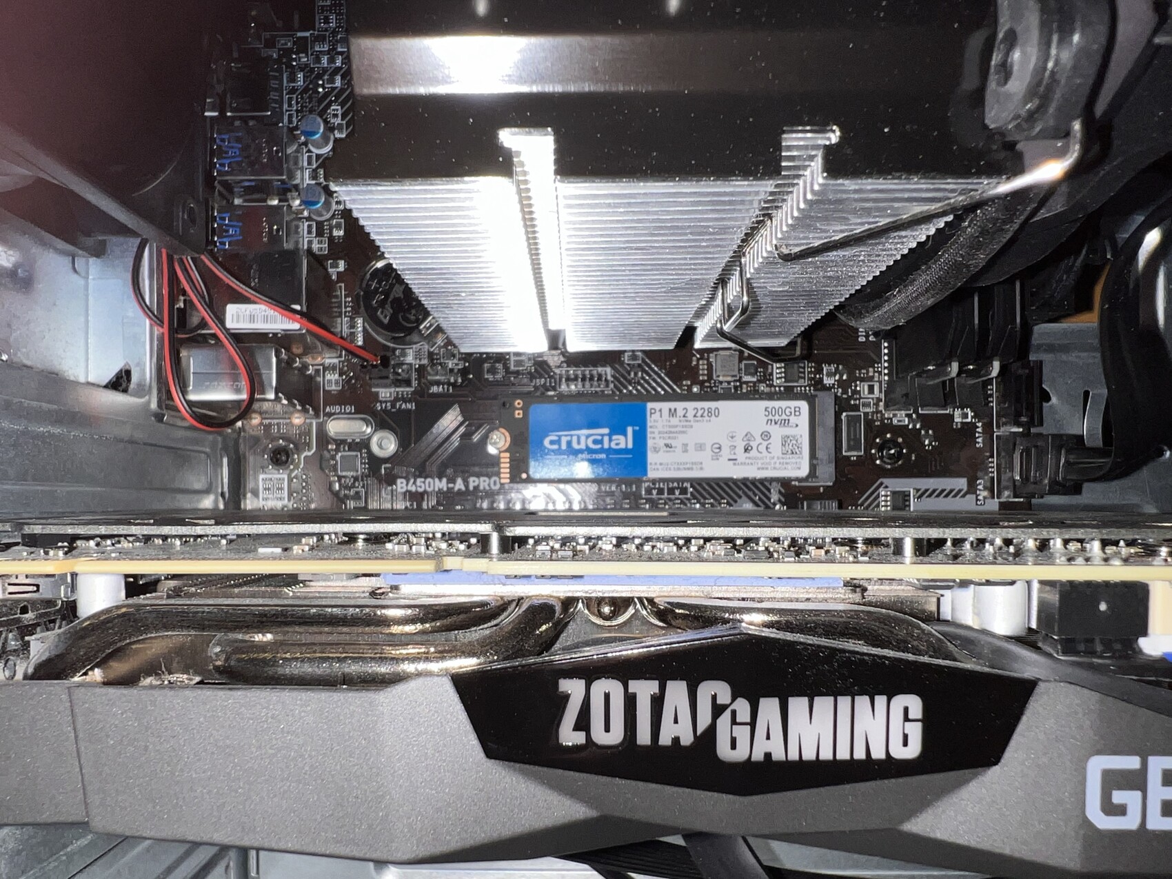 Blick ins PC-Gehäuse: Grafikkarte von ZOTAC, Crucial M.2-SSD, CPU-Kühler, Mainboard.