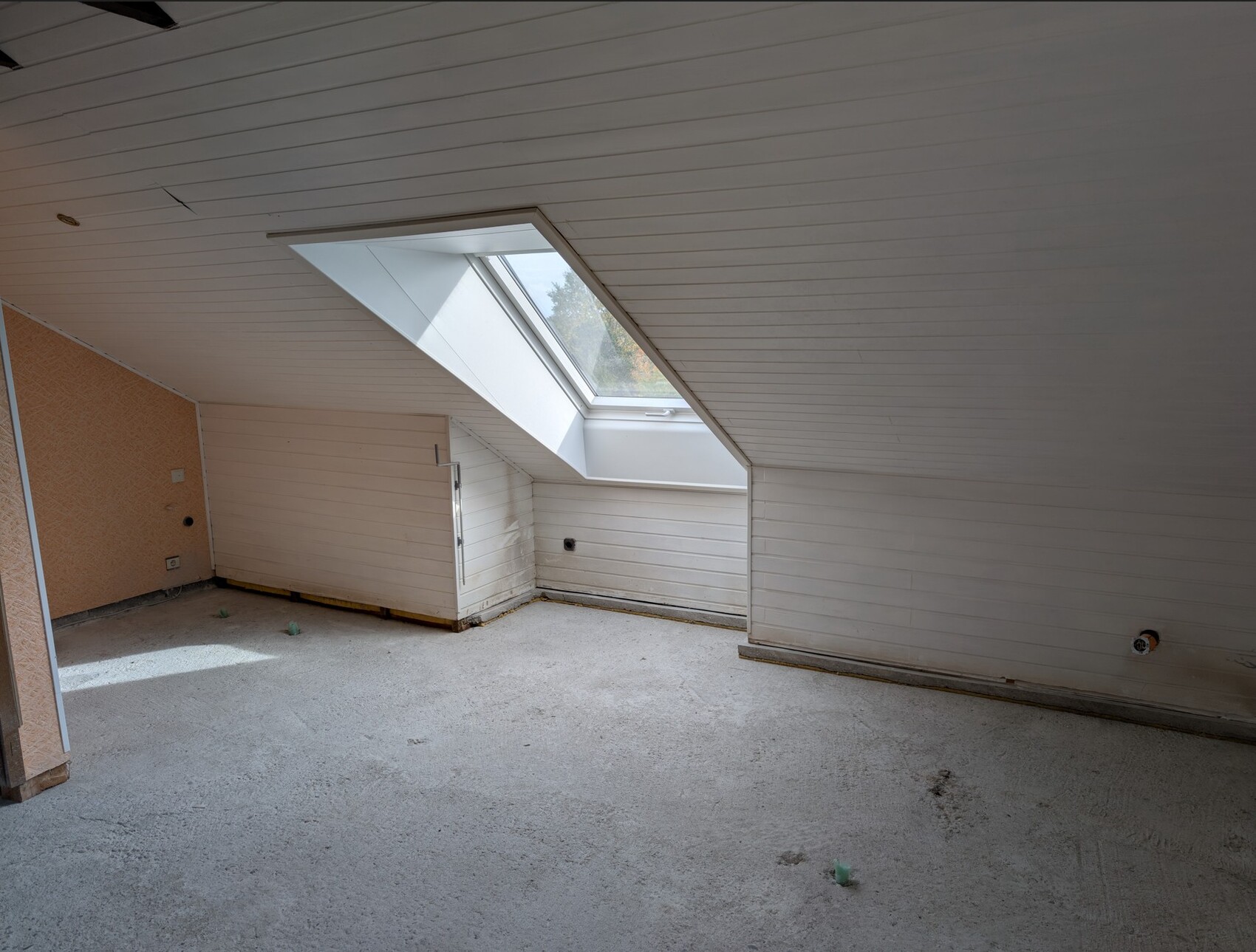 Heller Dachbodenraum mit schräger Decke und Dachfenster (Skylight).