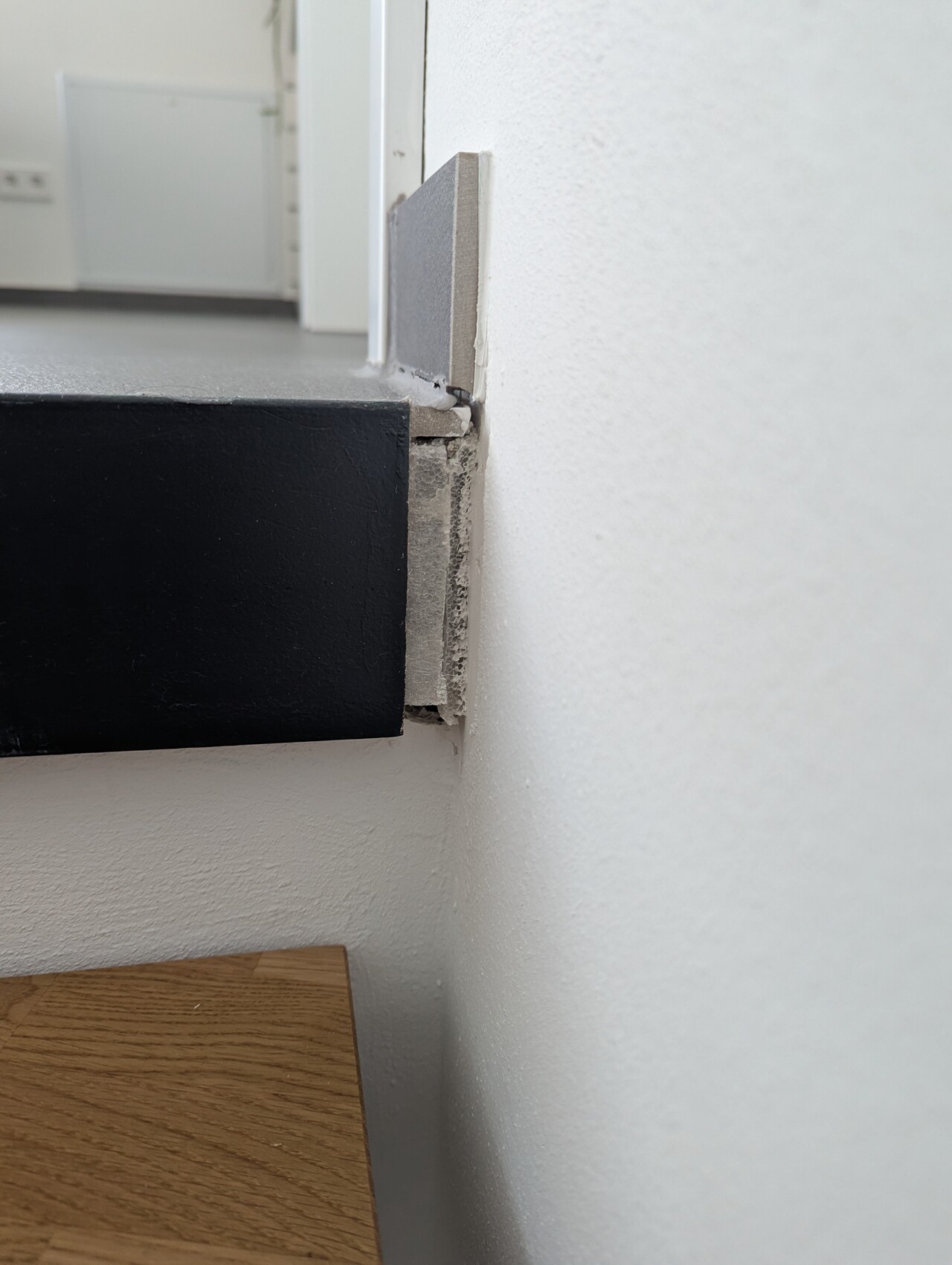 Nahaufnahme eines beschädigten Innenbodenrandes mit Spalt zwischen Boden und Wand