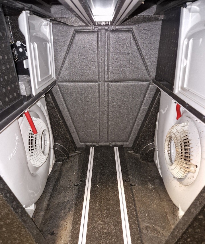 Kleiner Aufzug Innenraum mit schwarzen Wänden, Seitenmaschinen und Führungsschienen