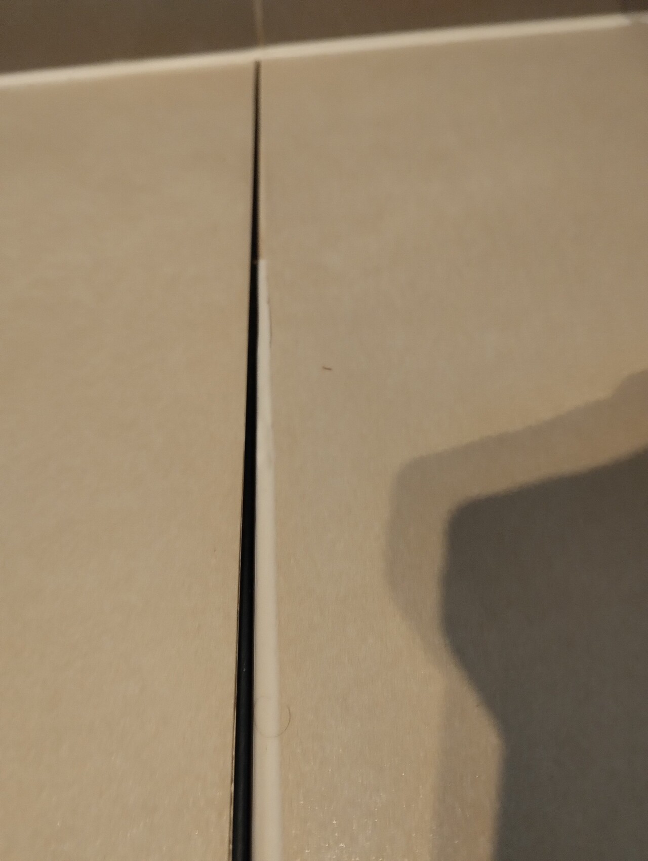 Nahaufnahme eines hell beigen Keramikfliesenbodens mit sichtbarer Fuge.