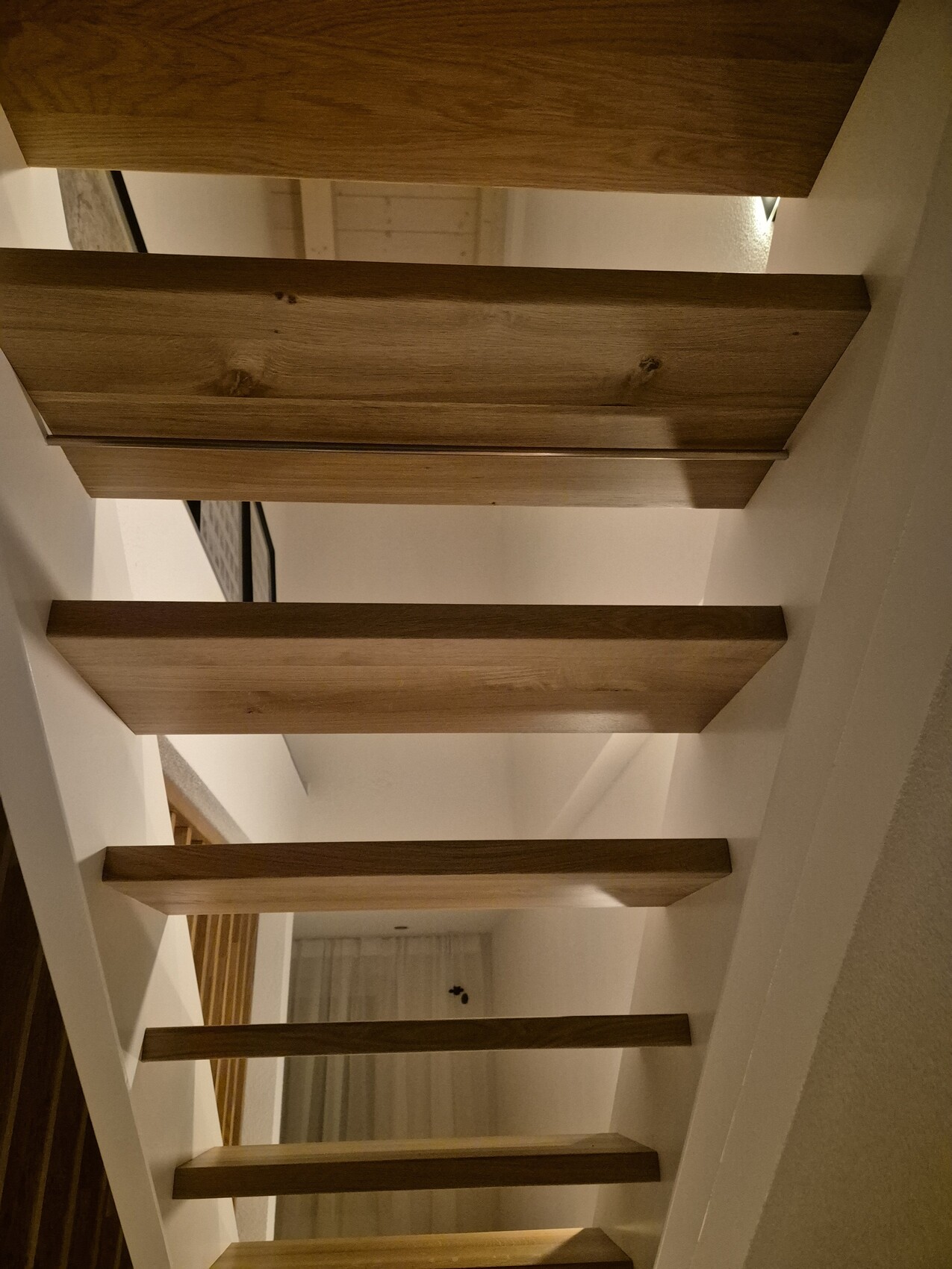 Moderne Holztreppe mit offenen Stufen in hellem Innenraum