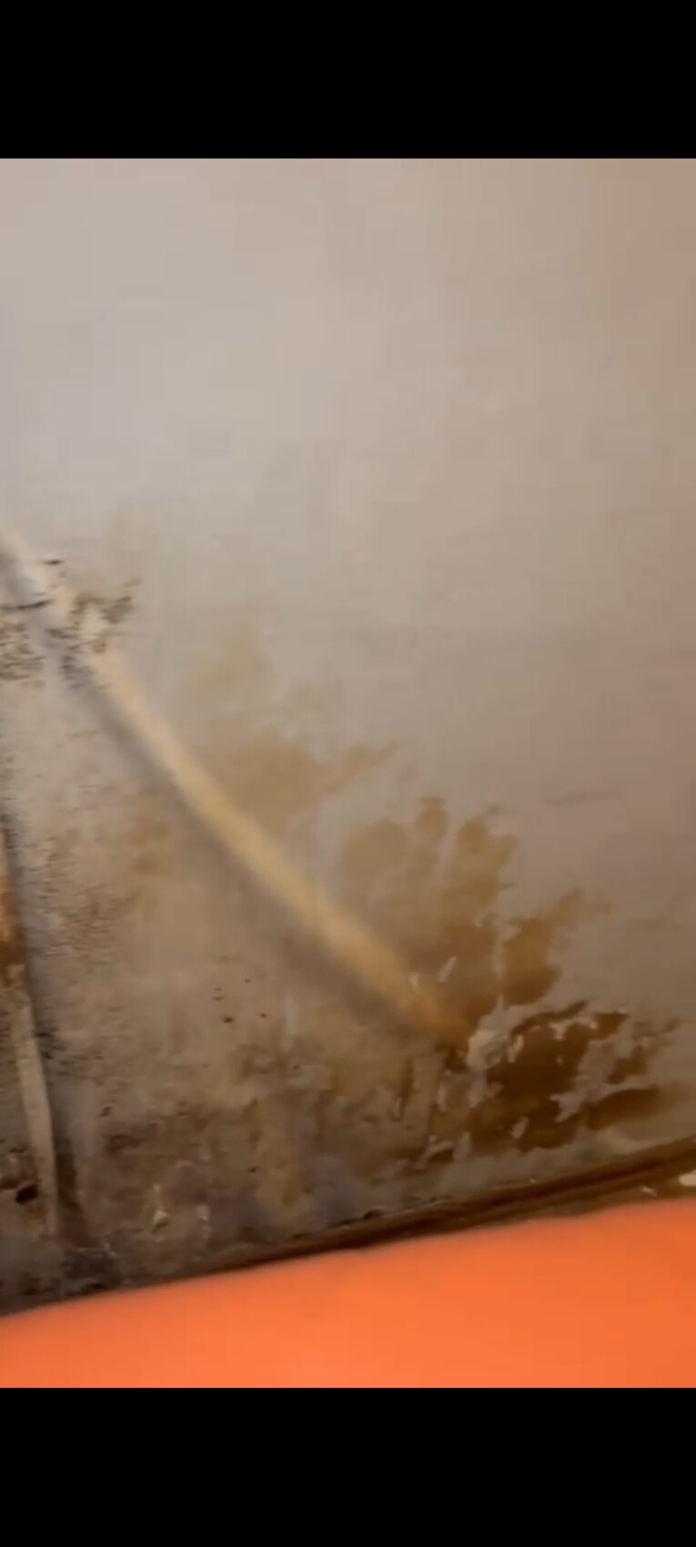 Feuchte Wand mit Wasserflecken am unteren Wandbereich, Anzeichen von Baumängeln