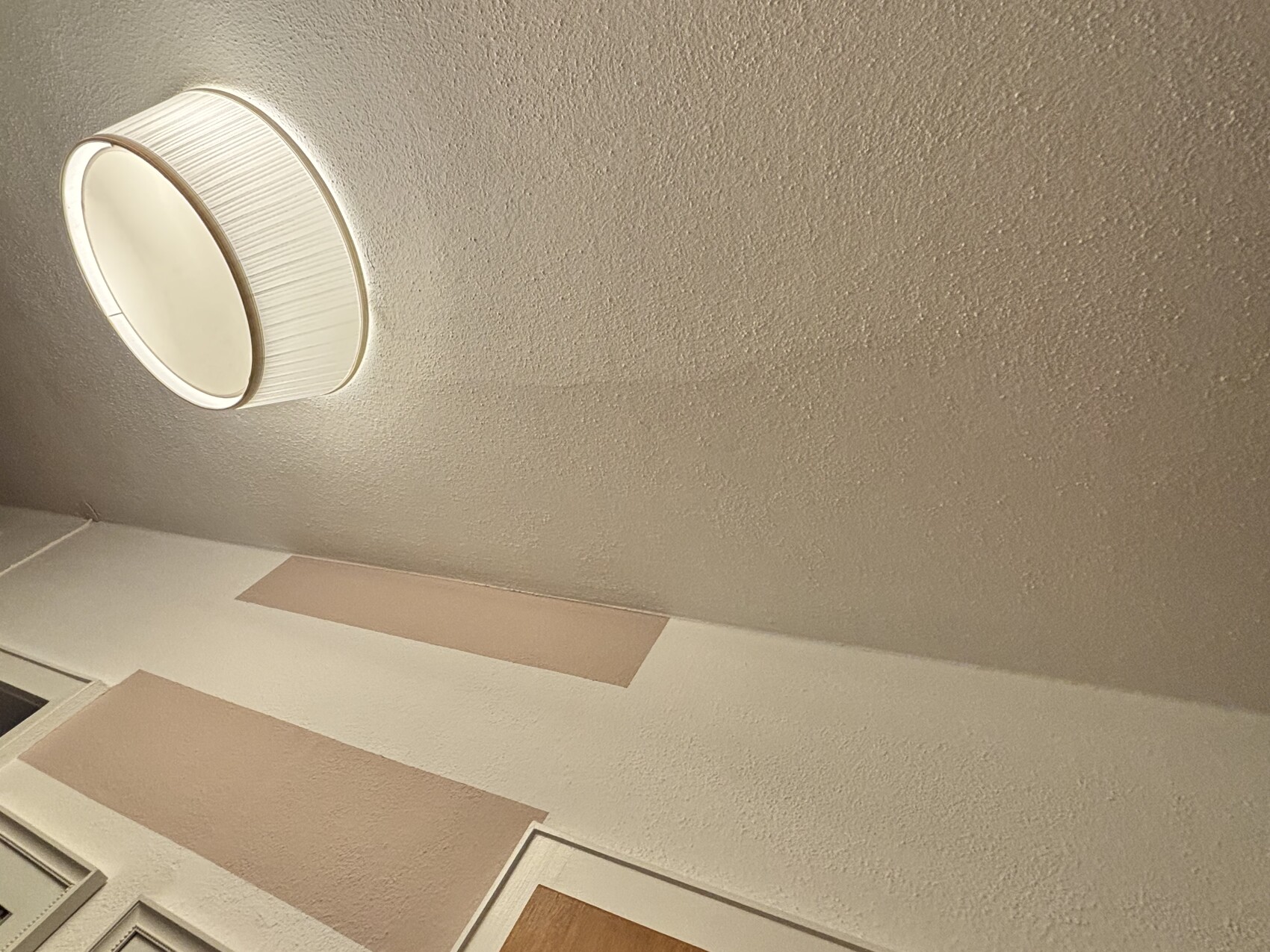 Runde Deckenlampe an texturierter Decke im Innenraum.