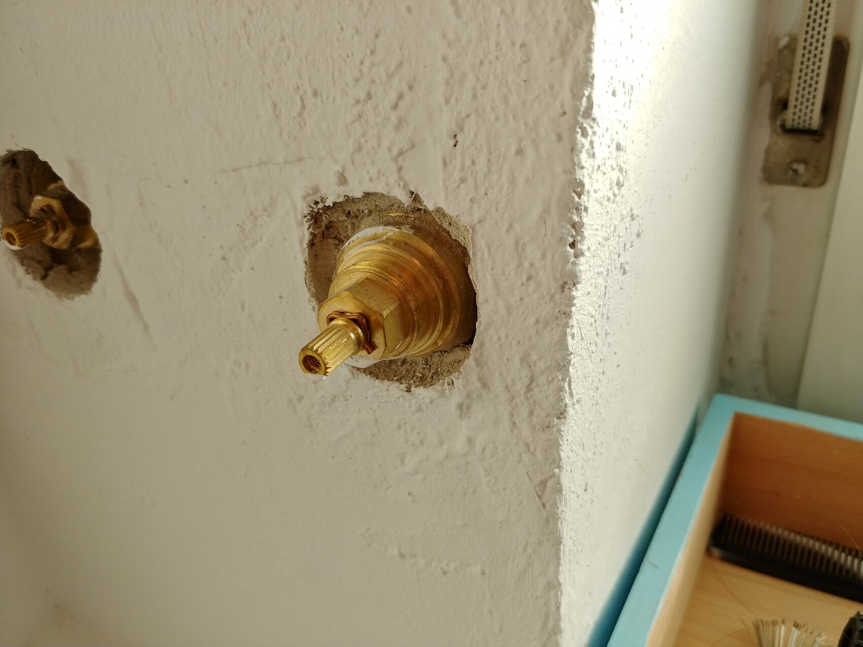 Nahaufnahme eines Messing-Absperrhahns im Bad an der Wand