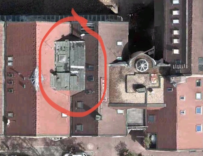 Luftbild eines Gebäudedaches mit roter Markierung eines Dachaufbaus