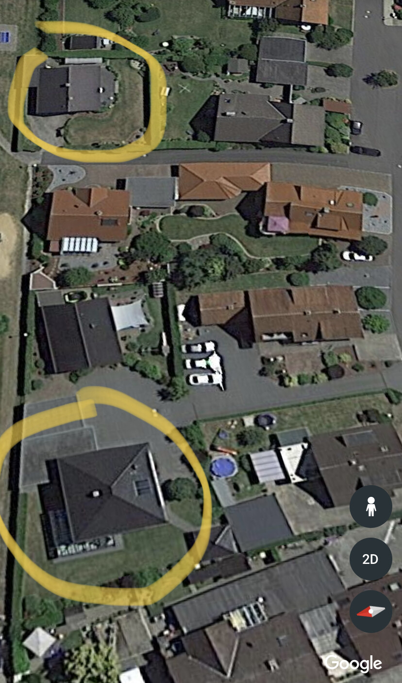 Luftaufnahme eines Wohnviertels von oben; zwei Gebäude sind gelb markiert (Kreise).