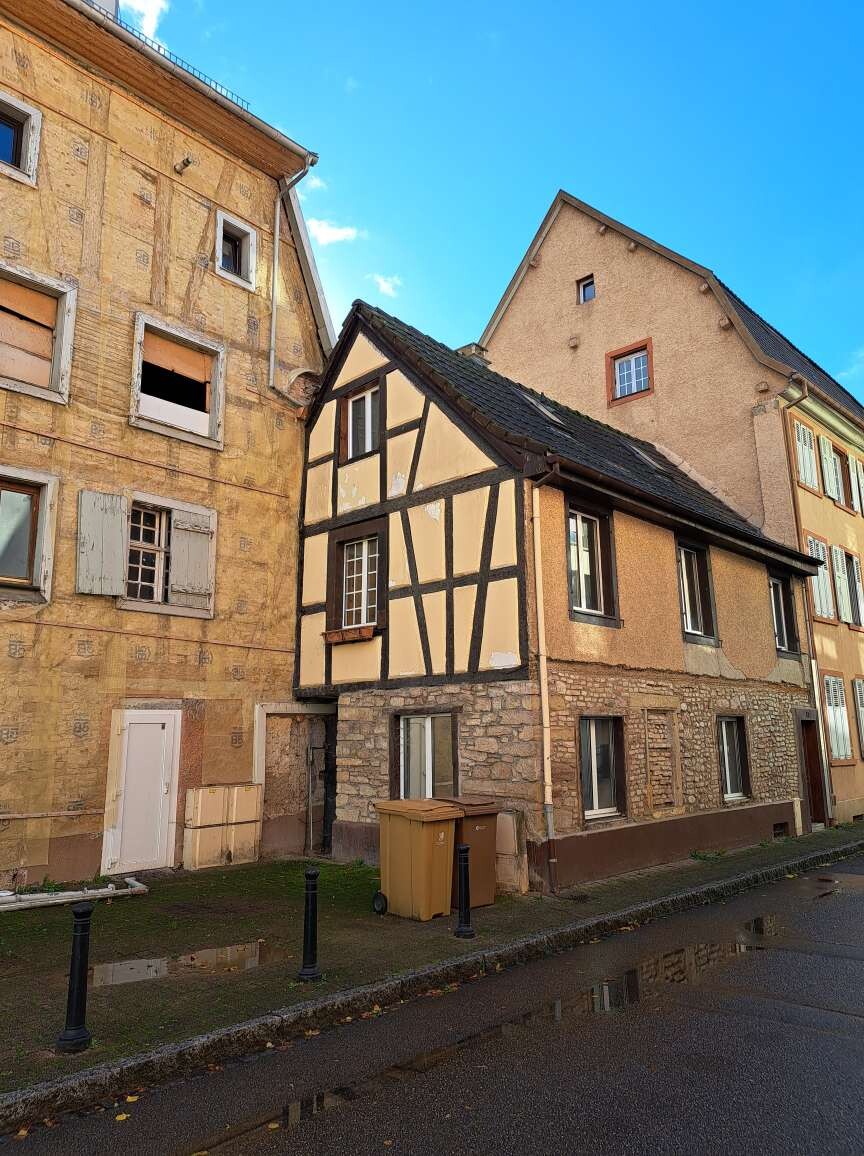 Historische Gebäude mit Fachwerk und Steinfassade an einer Straßenszene
