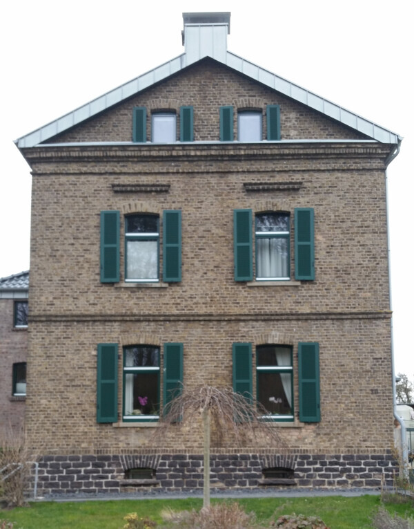 altbau-ziegelhaus-mit-gruenen-fensterlaeden.png