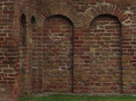 Alte rote Backsteinmauer mit gewölbten Arkaden