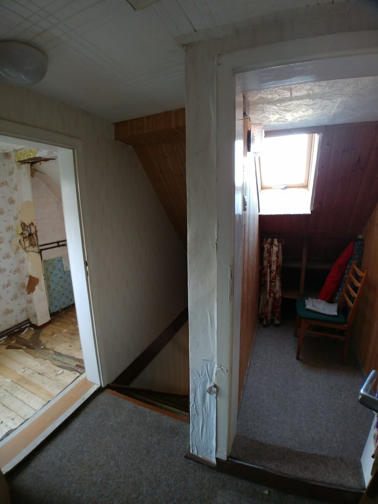 Korridor mit Treppe nach unten, altes Haus, Holzverkleidung und Dachbodenfenster