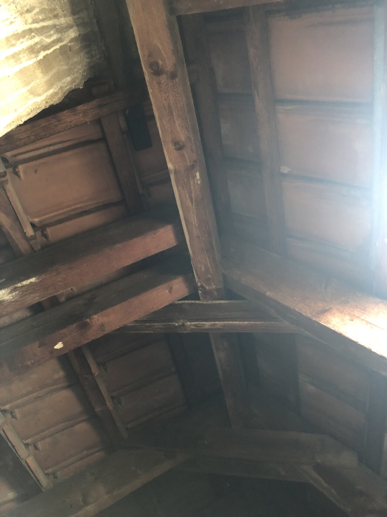 Sichtbare Dachkonstruktion aus Holzbalken im Dachboden.