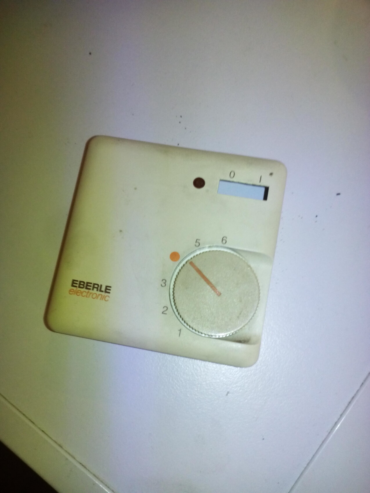 Beige vintage Wanddimmer mit rundem Drehknopf und Schieberegler an der Wand