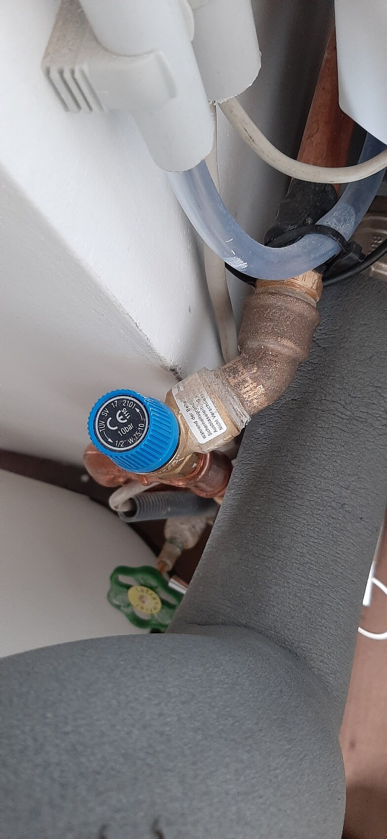 Kupferrohr mit Druckregler und blauem Einstellknopf in einer Sanitäranlage