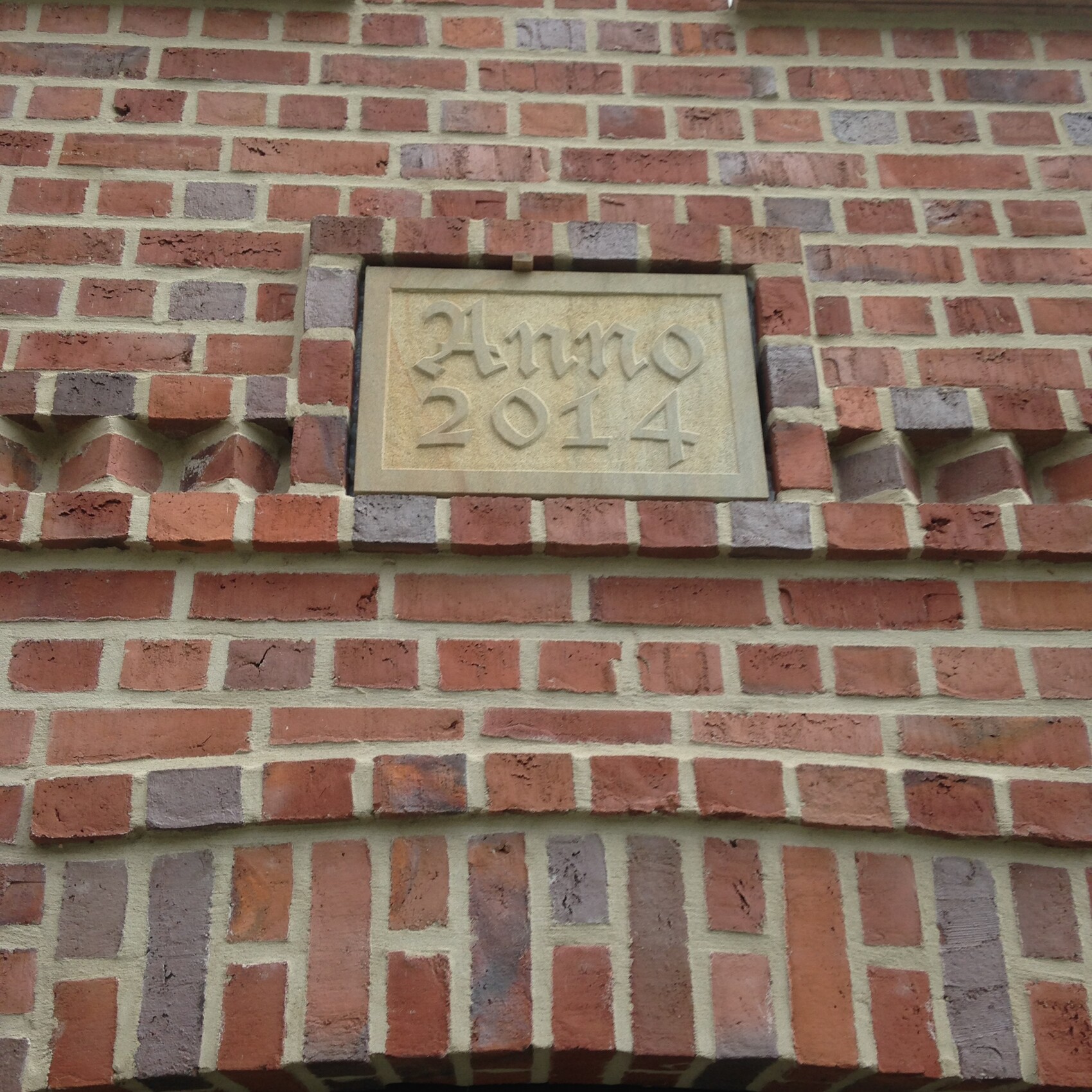 Backsteinfassade mit Steinplakette Anno 2014 an der Wand