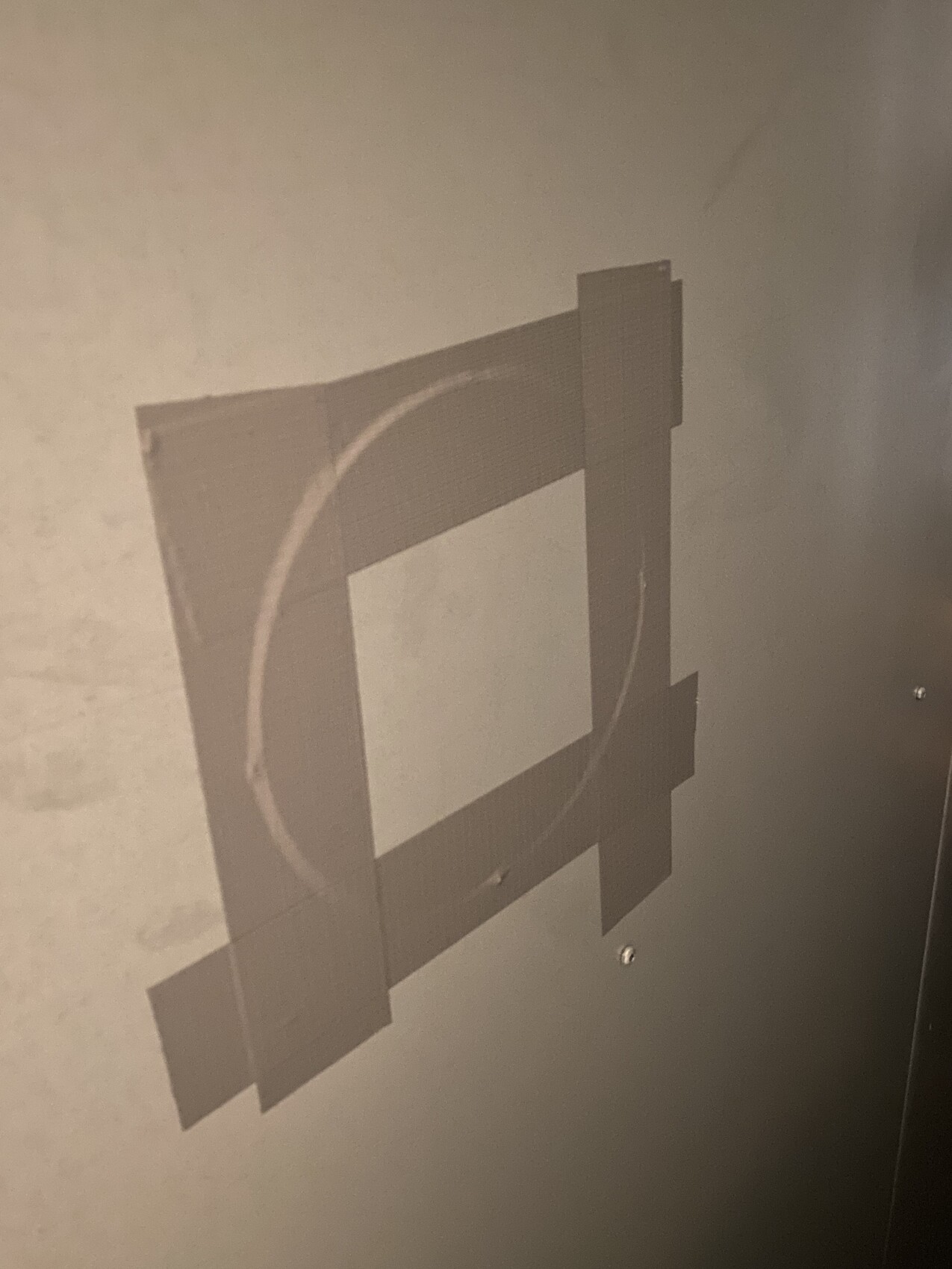 Holzrahmen aus Balken an einer Betonwand, quadratischer Rahmen mit kreisförmigem Innenring.