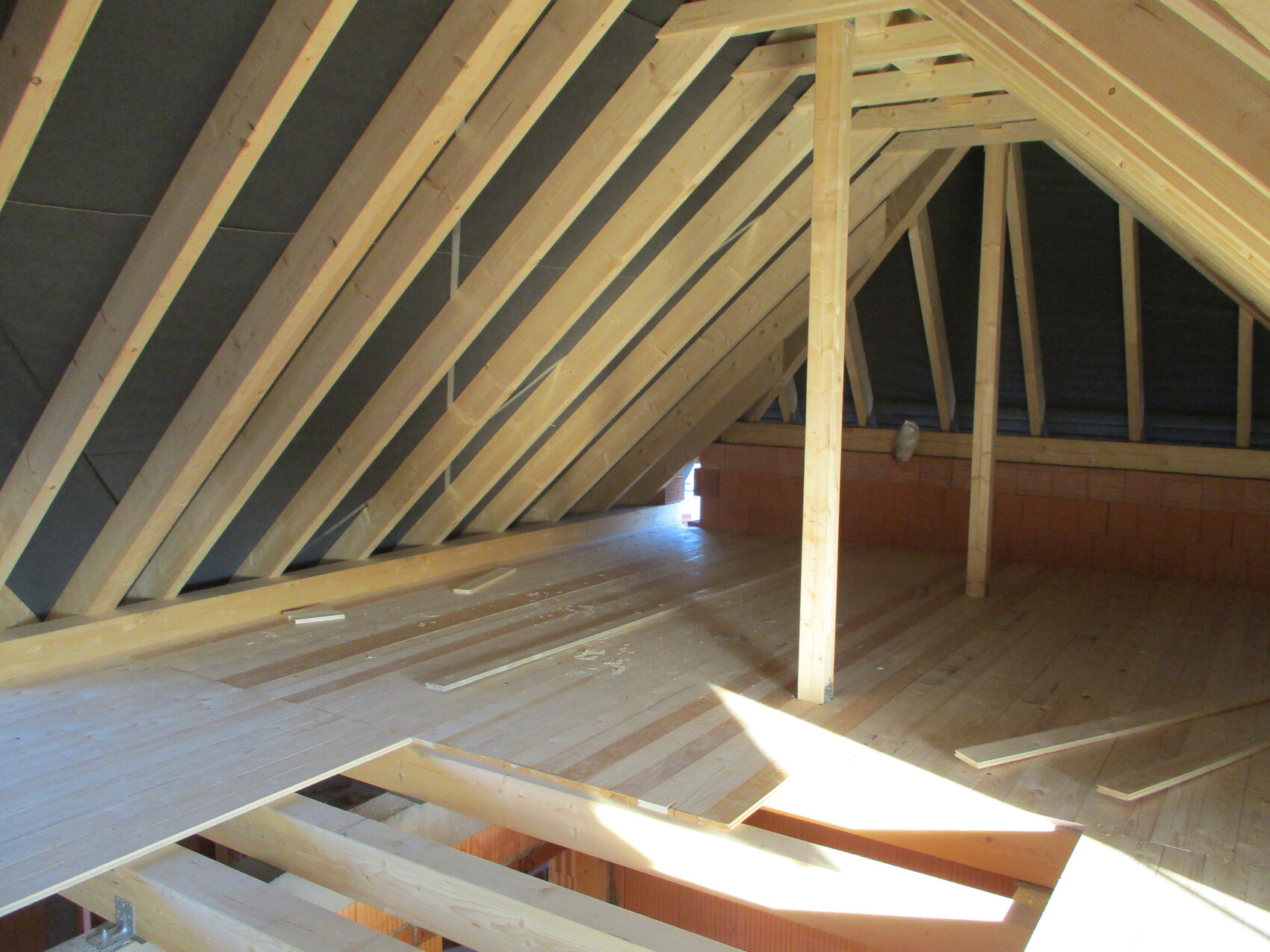 Dachboden mit sichtbaren Holz-Dachsparren und Rohbau im Dachgeschoss.