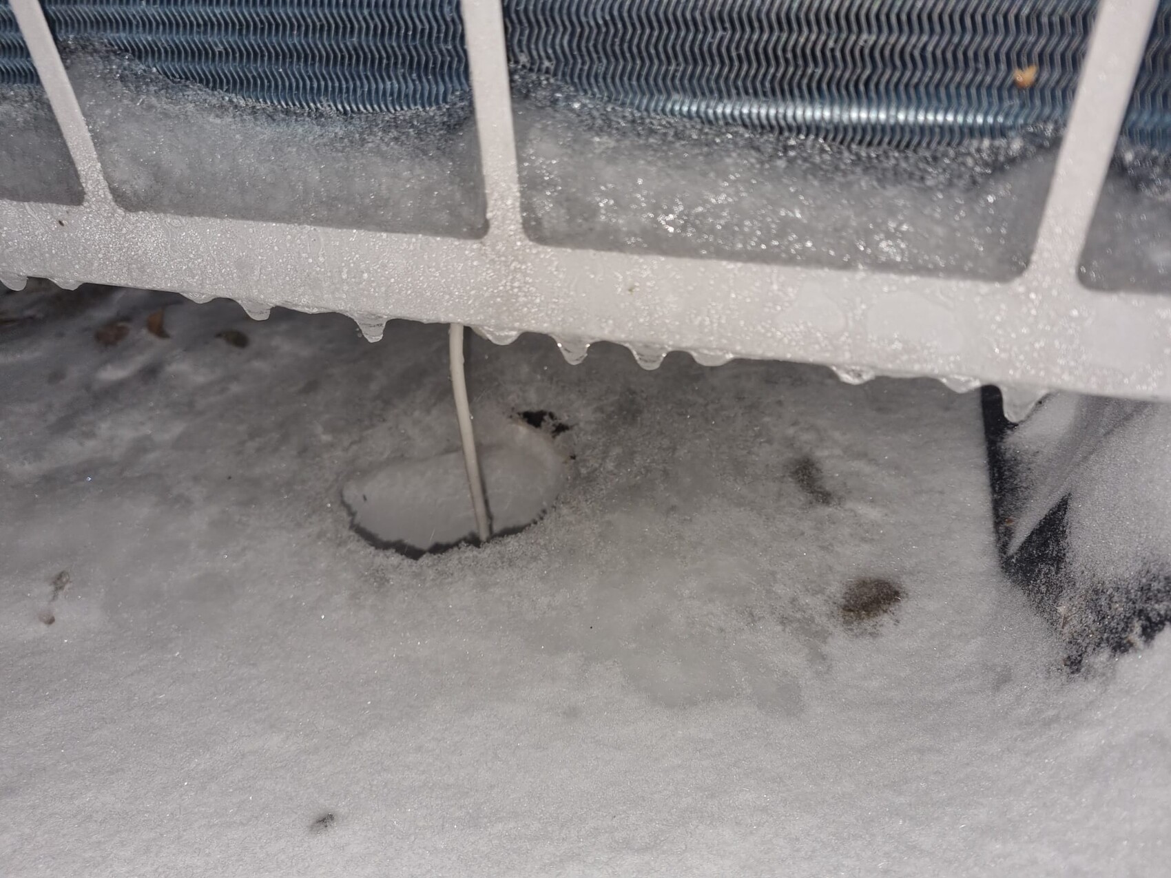 Außen-Klimageraet im Frost, Schneedecke und sichtbare Rohrleitung