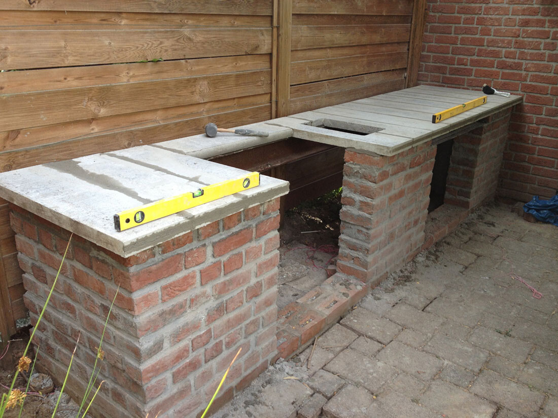 Außenküchenbereich aus Backstein mit Betonplatten und Holzverkleidung