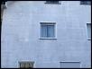 Außenansicht einer hellblauen Fassadenwand mit Fenster