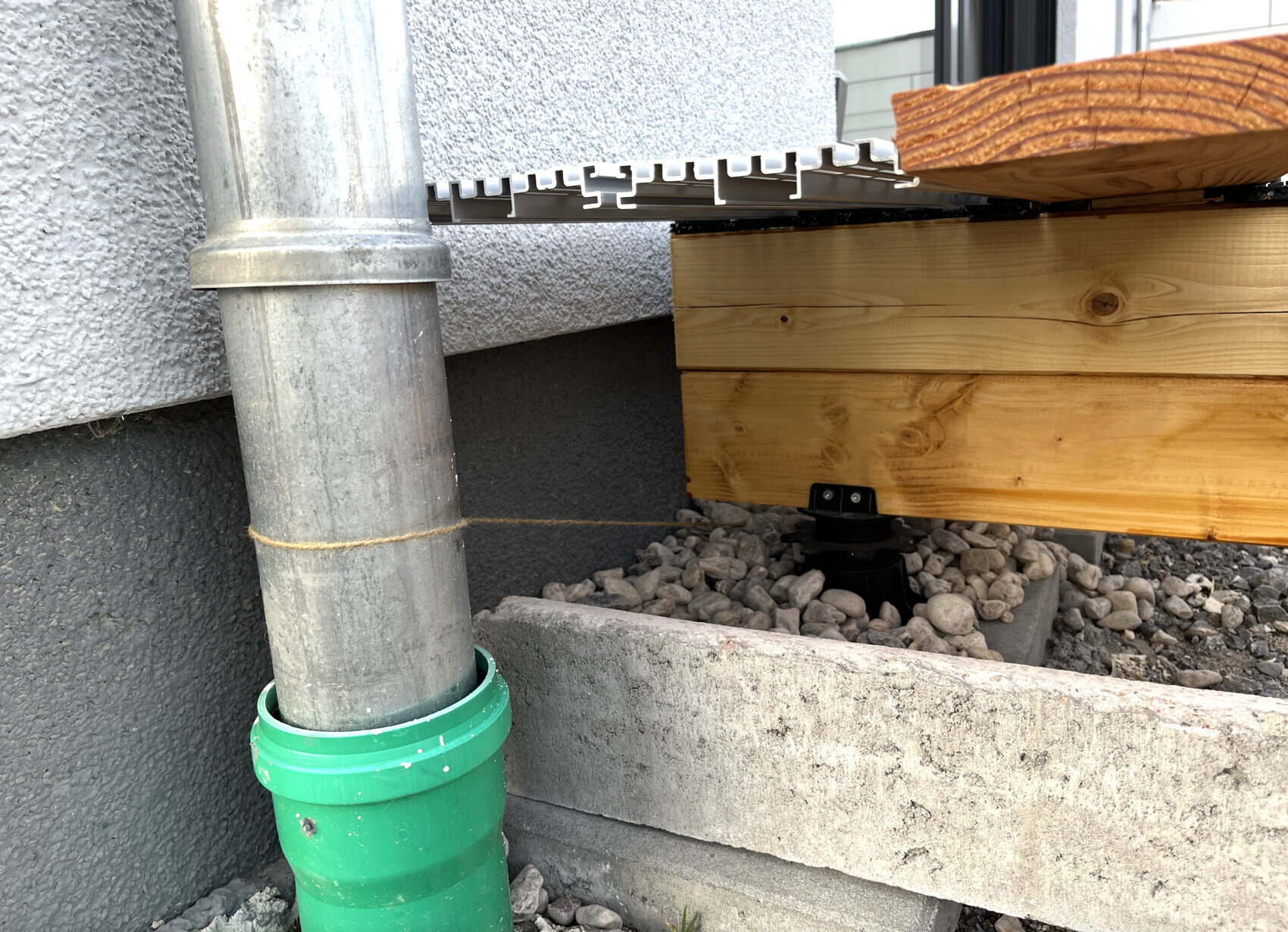 aussenbereich-downpipe-regenwasser-terrasse-holzfundament.png