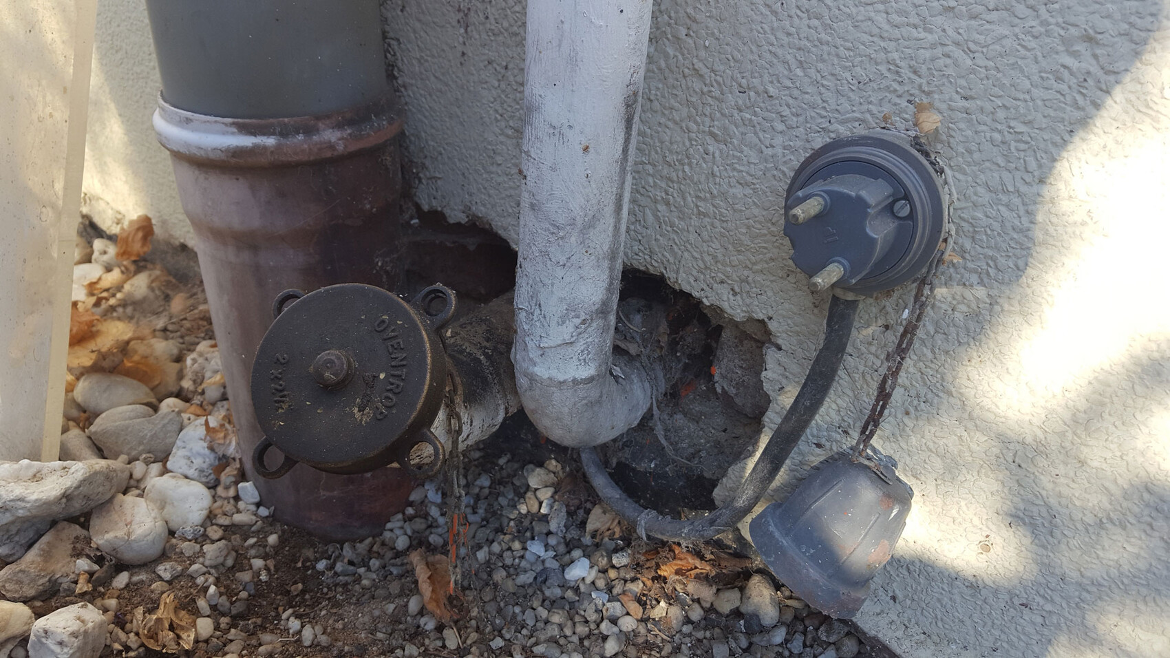 Außenbereich: Wasserleitungen, Armaturen und Anschlussstücke an der Hauswand